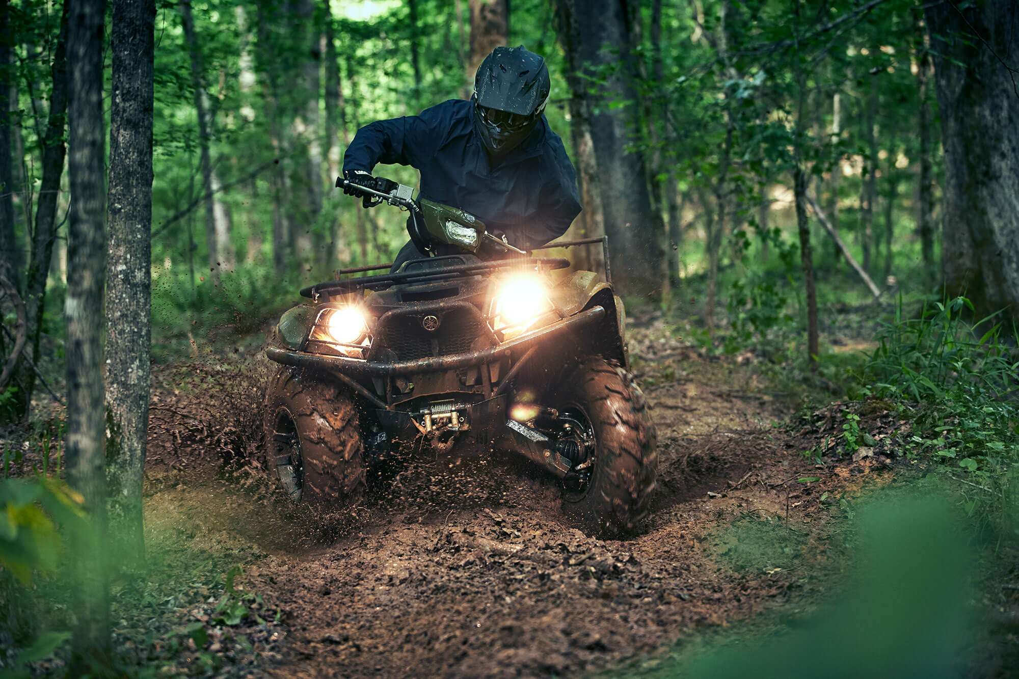 A man driving an ATV in the woods
