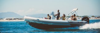 family driving a zodiac inflatable boat